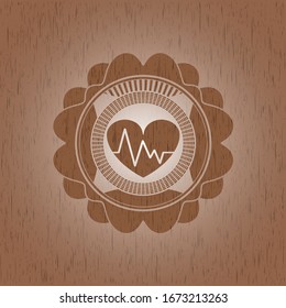 heart with electrocardiogram icon inside badge with wood background