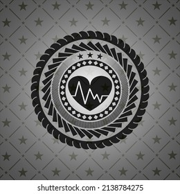 corazón con ícono de electrocardiograma dentro de placa o emblema oscuro. 