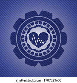 corazón con icono del electrocardiograma dentro del fondo del denim. 