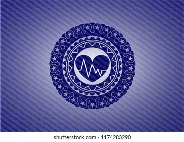 heart with electrocardiogram icon inside emblem with denim texture