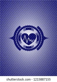 heart with electrocardiogram icon inside emblem with jean background