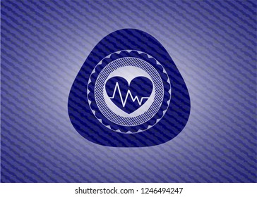 heart with electrocardiogram icon inside emblem with jean background