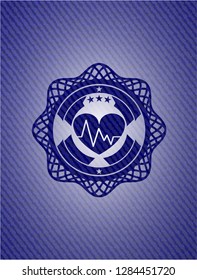 heart with electrocardiogram icon inside emblem with jean background