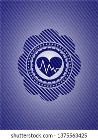 heart with electrocardiogram icon inside emblem with denim texture