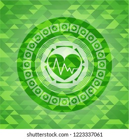 heart with electrocardiogram icon inside green emblem with triangle mosaic background