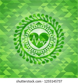 heart with electrocardiogram icon inside green emblem with triangle mosaic background
