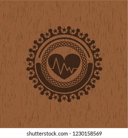 heart with electrocardiogram icon inside retro style wood emblem