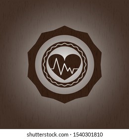 heart with electrocardiogram icon inside retro style wood emblem