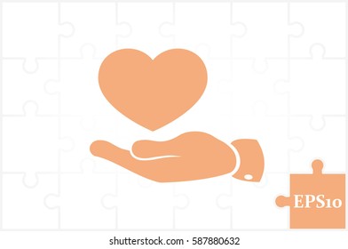 Heart in hand vector icon.