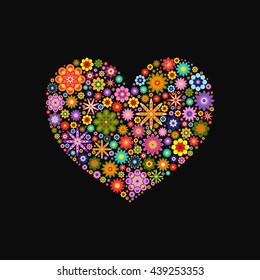 Heart laid out various flowers of different colors on black
