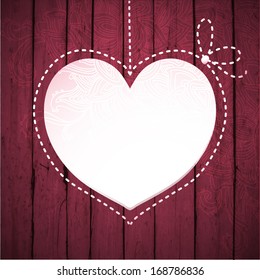 Heart on wood background. Decorative heart hanging on a wooden background. 