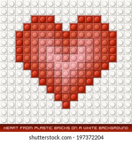 Herz aus Plastiksteinen auf weißem Hintergrund. Rot
