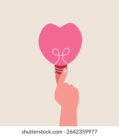 a heart shape light bulb in human hand