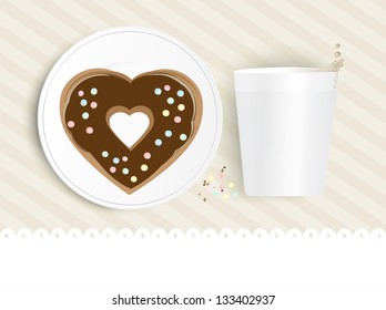 Heart shaped chocolate doughnut topped with colourful sprinkles on a plate with a cup of liquid refreshment with drops splashing from the top against a neutral striped background