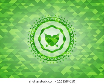 heart with two arrows icon inside green mosaic emblem