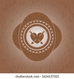 heart with two arrows icon inside vintage wooden emblem