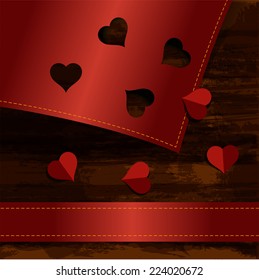 hearts cut from red paper on wood texture