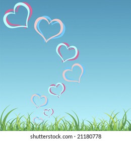 Hearts floating in the air over grass and blue sky