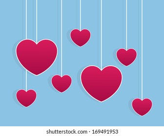 Hearts hanging on strings in sky 