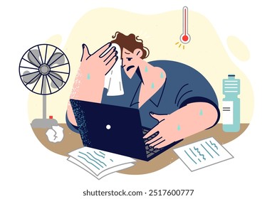 Heat torments male freelancer wiping sweat while working with laptop and using electric fan. Summer weather and heat causes discomfort for guy suffering due to lack of air conditioning in room