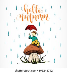 Hello Autumn calligraphy handwritten phrase. Vector sketch cartoon style of boy with umbrella sitting on big mushroom under rain. Colored vector illustration .