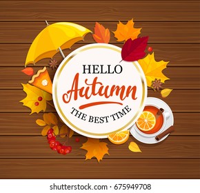 Hello Autumn lettering in gold frame on wooden background with umbrella, pumpkin pie, tea and autumn leaves. Vector illustration.