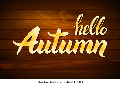 hello autumn lettering. Hand-written words on wood background. vector art