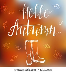 "Hello, autumn" template with blurred background,  modern lettering and hand drawn rain boots