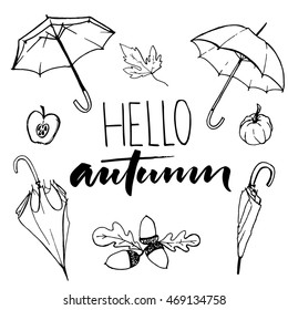 Hello autumn text and sketches of open and closed umbrellas, acorns, pumpkin and half of an apple. Black and white fall doodles