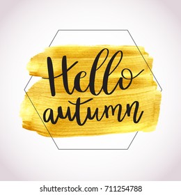 Hello Autumn. Vector illustration of lettering phrase on golden paint stain banner. Vector gold paint. Autumn calligraphy composition with gold brush painted textured stain.