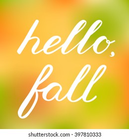 Hello, fall. Handwritten illustration, hand made brush lettering on blurred background. Cute handwriting, can be used for greeting cards, scrapbooks, photo overlays and more.