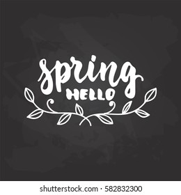 Hello, spring - hand drawn lettering phrase isolated on the black chalkboard background. Fun brush ink inscription for photo overlays, greeting card or t-shirt print, poster design