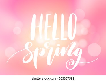 Hello spring hand drawn lettering design isolated on a abstract blurred background.