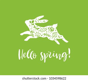 Hello spring. Running silhouette of a rabbit with flowers on a green background. Calligraphy card. Hand drawn design elements. Handwritten modern brush lettering. Vector illustration.