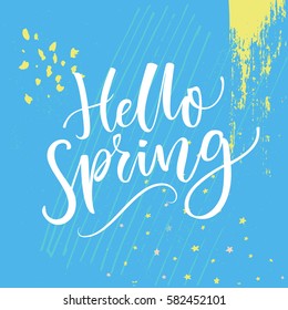 Hello spring text, modern calligraphy at blue grunge background with hand marks.