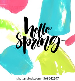 Hello spring text on colorful background with pink, green and blue brush strokes