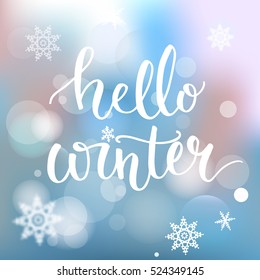 Hello winter banner. Brush calligraphy at blue winter background with snowflakes and bokeh lights. Vector card design with typography.