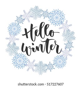 Hello winter black hand written inscription with blue snowflakes wreath on white background