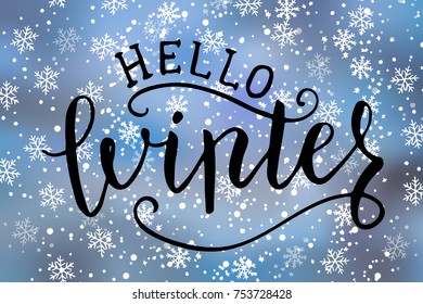 Hello winter brush hand lettering quote on blue rectangular background with hand drawn snowflakes
