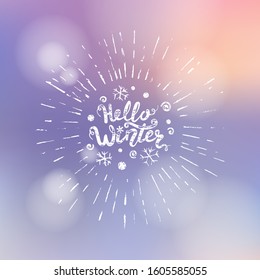 Hello winter title. Brush lettering at blurred winter background with bokeh lights. Vector card design with handwritten calligraphy