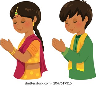 Hindu boy and girl in traditional Indian outfits praying on Diwali.