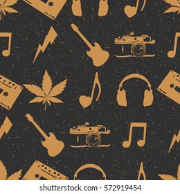 Hippie seamless pattern with marijuana leaves, headphones, old camera, heart, guitar,  music note, cassette records on dark background. Wrapping paper. Vector illustration