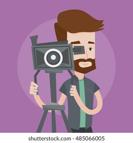 A hipster cameraman with the beard looking through movie camera on a tripod. Young man with professional video camera. A cameraman taking a video. Vector flat design illustration. Square layout.