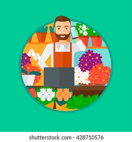 A hipster florist with the beard using telephone and laptop to take orders. A florist standing behind the counter at flower shop. Vector flat design illustration in the circle isolated on background.