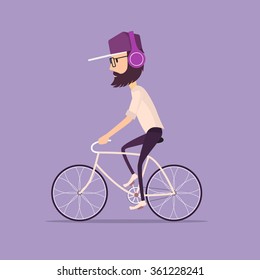 Hipster man in a baseball cap riding a vintage bicycle. Guy listening to music with modern purple headphones wearing light shirt and tight black jeans and trendy glasses.