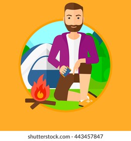 A hipster man with the beard kindling a campfire on the background of camping site with tent. Tourist relaxing near bonfire. Vector flat design illustration in the circle isolated on background.