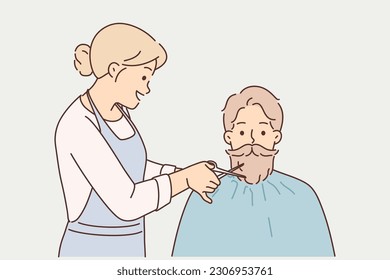 Hipster man cuts beard in beauty salon, wanting to have attractive appearance and stand out from crowd. Woman hairdresser from barbershop cuts beard and mustache to guy who does not want to shave