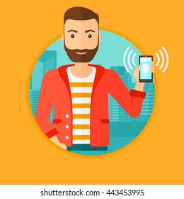 A hipster man holding ringing mobile phone on a city background. Young man answering a phone call. Man with ringing phone in hand. Vector flat design illustration in the circle isolated on background.