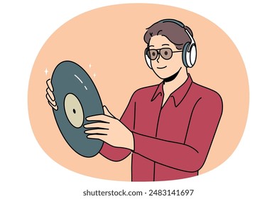 Hipster man with vinyl record listens to music in headphones, collecting retro discs with audio recordings. Guy looks at vinyl record and rejoices in buying rare copy with recording of concert