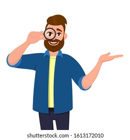 Hipster young man looking through magnifier and presenting/pointing hand to copy space. Bearded person holding magnifying glass or lens and introducing something. Male character in vector cartoon.